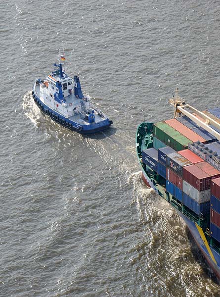 Die FAIRPLAY VI hat vor dem Burchardkai ein Containerschiff am Haken.