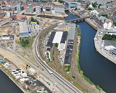 Das Areal ist zwischen Bahndamm und Hafenbecken eingeklemmt und bildet eine Art Exklave innerhalb der HafenCity.