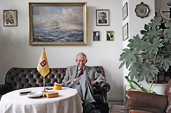 Otto Heinrich Steinmeier in der Sitzecke seines Büros. Auf dem Tisch die Firmenflagge und ein Aschenbecher der HAPAG.